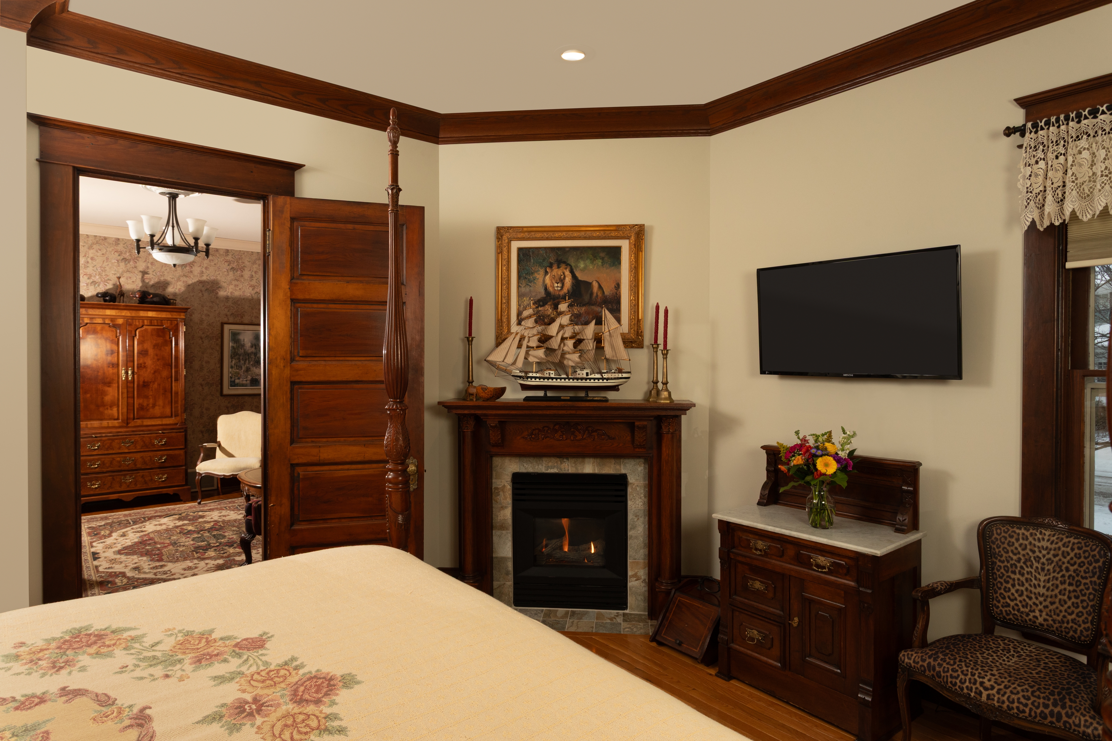 Master Suite Bedroom with a four-poster bed, antique wooden furniture, and patterned rug.