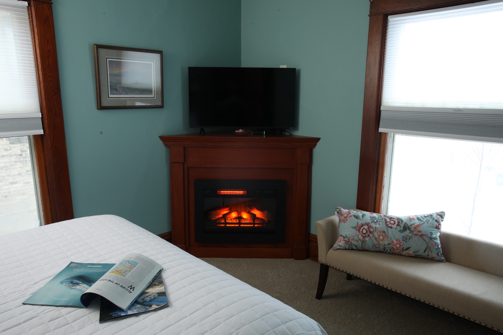 Bedroom with a large bed, fireplace, and a mirror reflecting another bed.