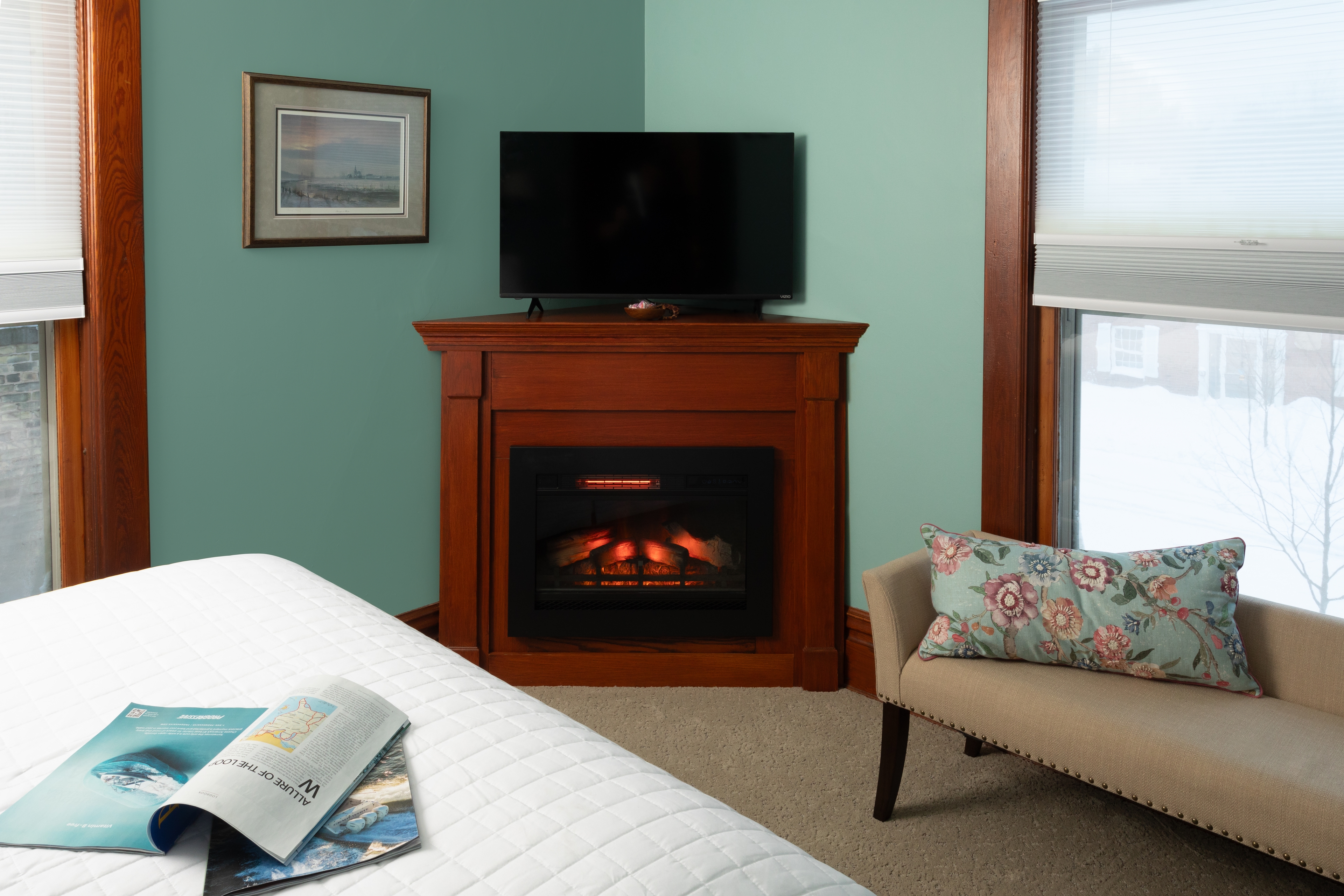 Room 2 with a Queen bed, fireplace, and sitting bench.