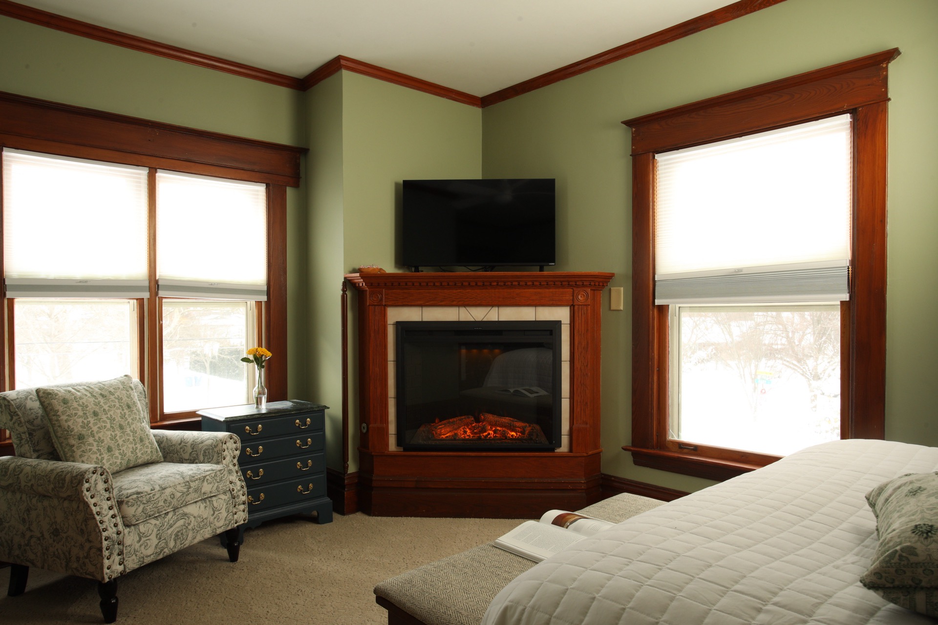 Bedroom with Clary Sage walls, a fireplace, and a sink vanity facing Butler Street.