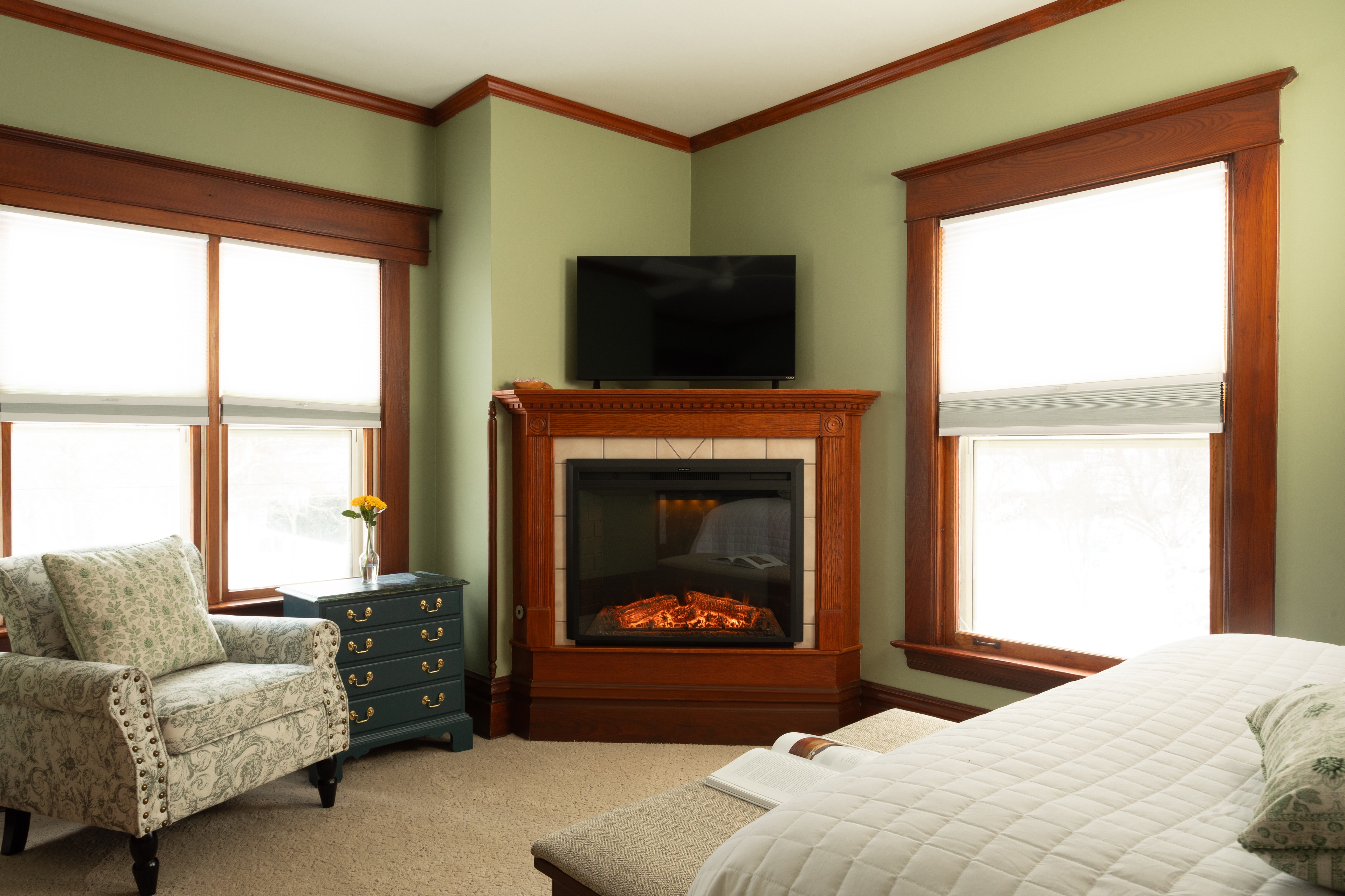 Bedroom with Clary Sage walls, a fireplace, and a sink vanity facing Butler Street.