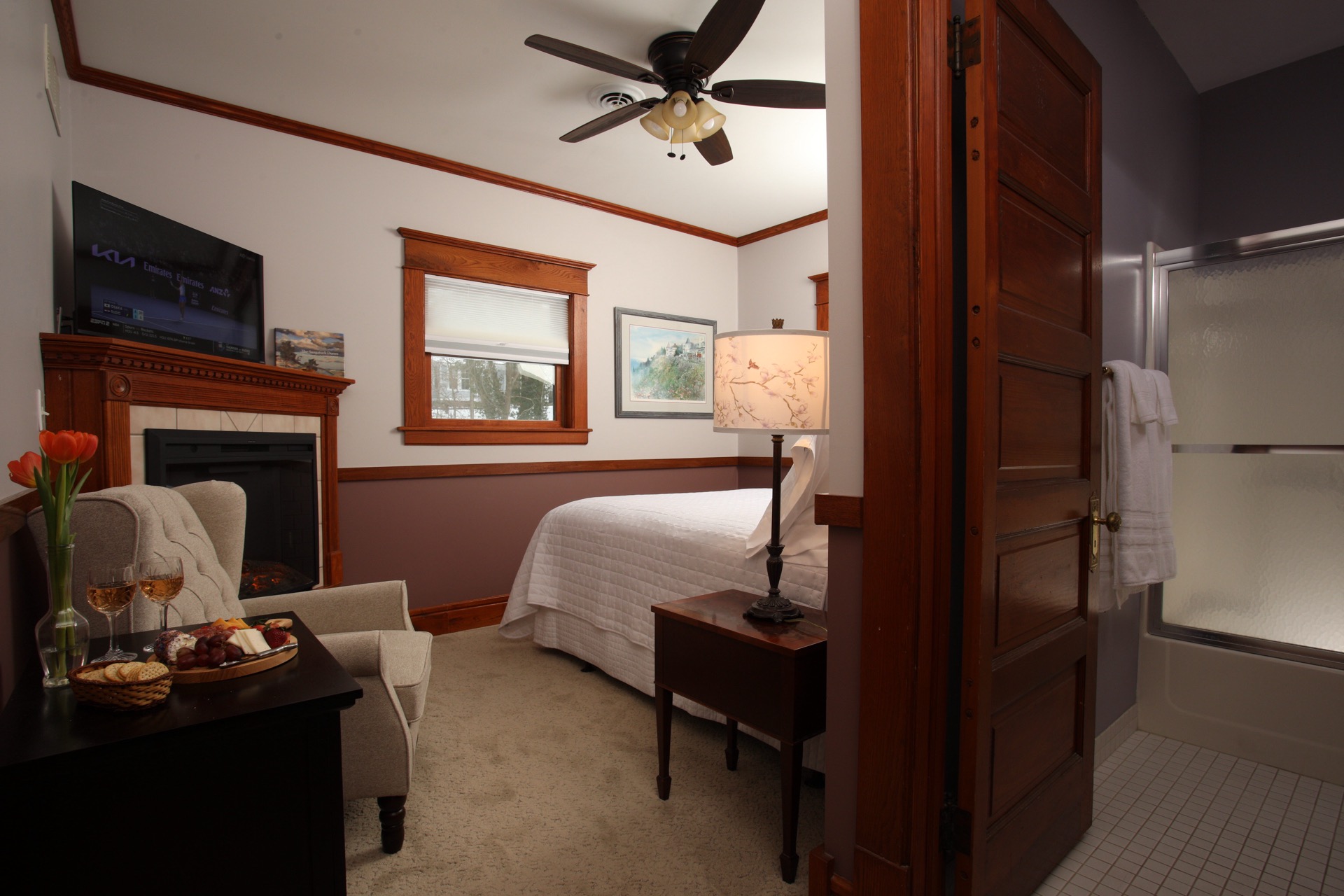 Two tone bedroom with a 2 post Heckman bed,  a fireplace, and a flat-screen TV.