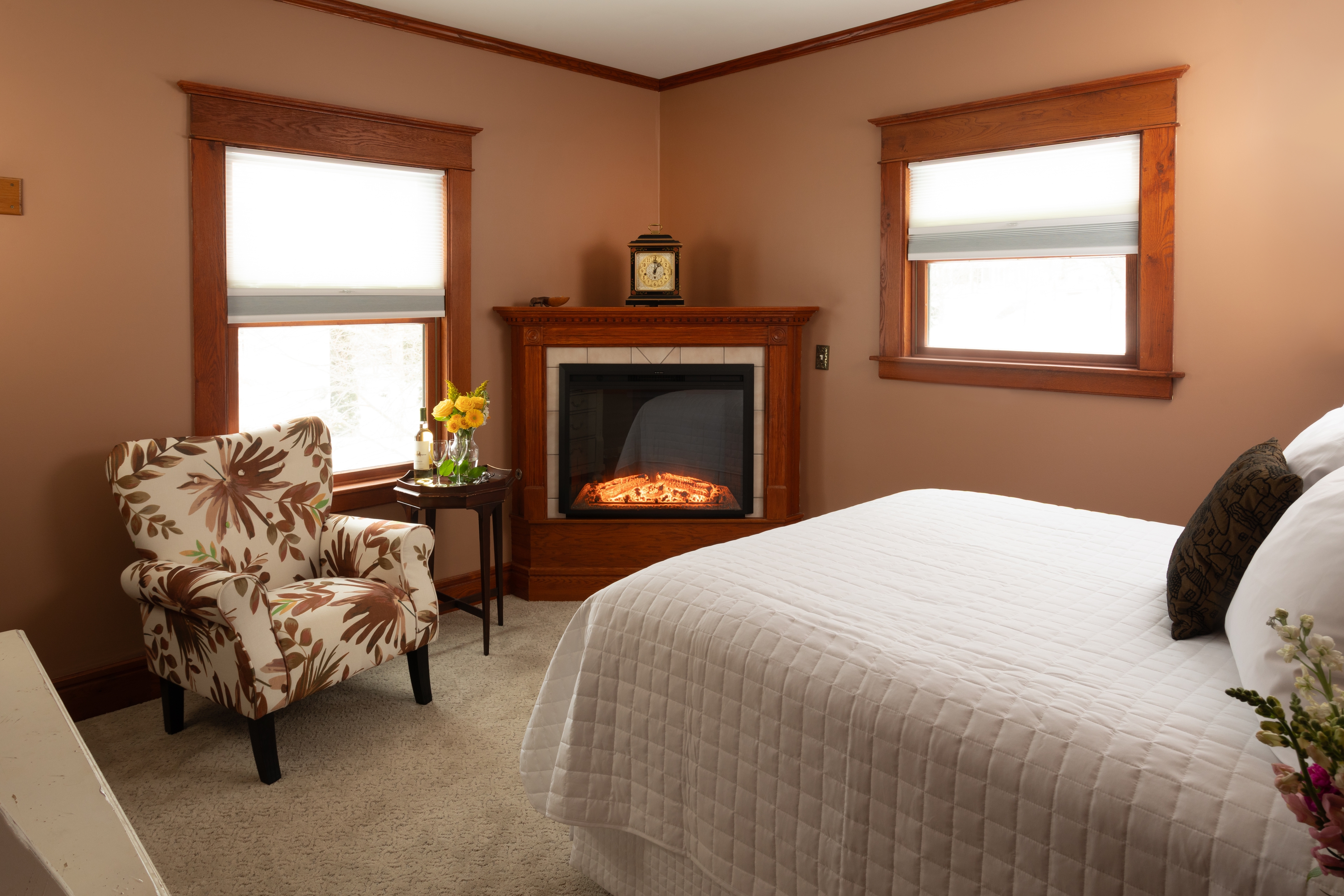 Bedroom with Queen bed, a fireplace, and Rose Renwick painted walls.