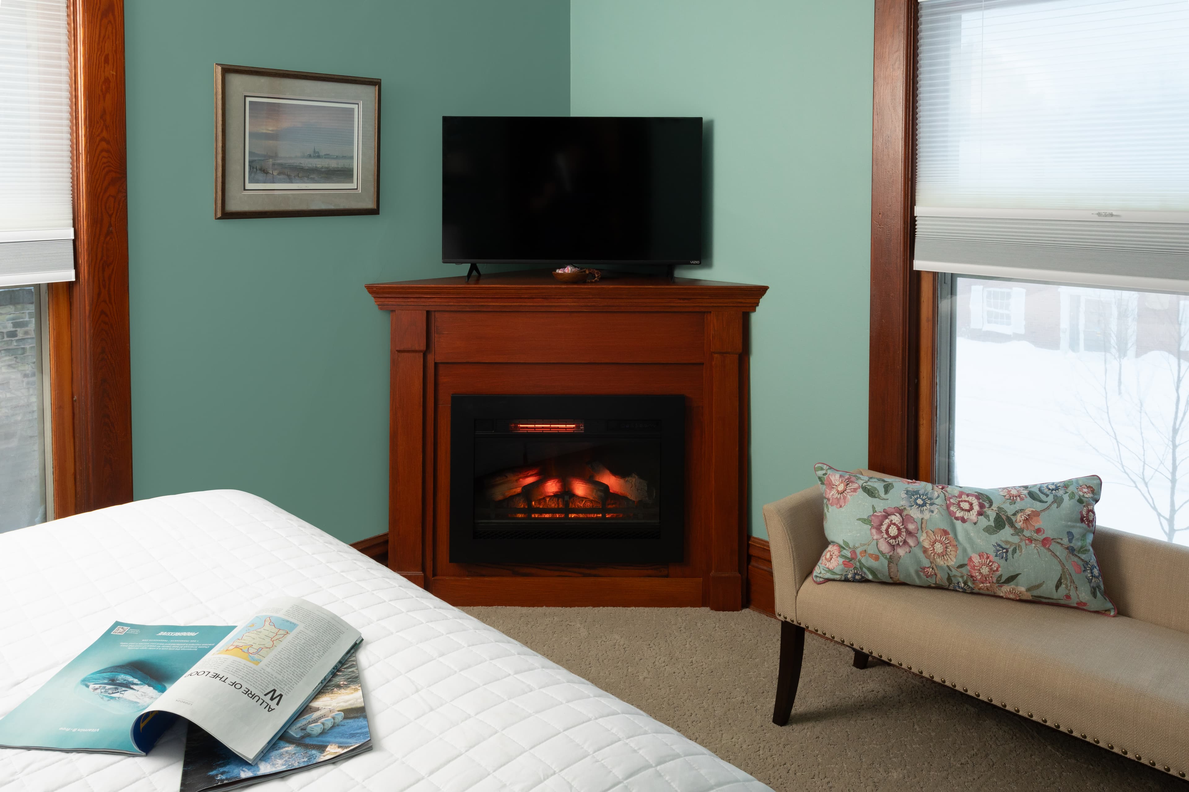 Room 2 with a Queen bed, fireplace, and sitting bench.