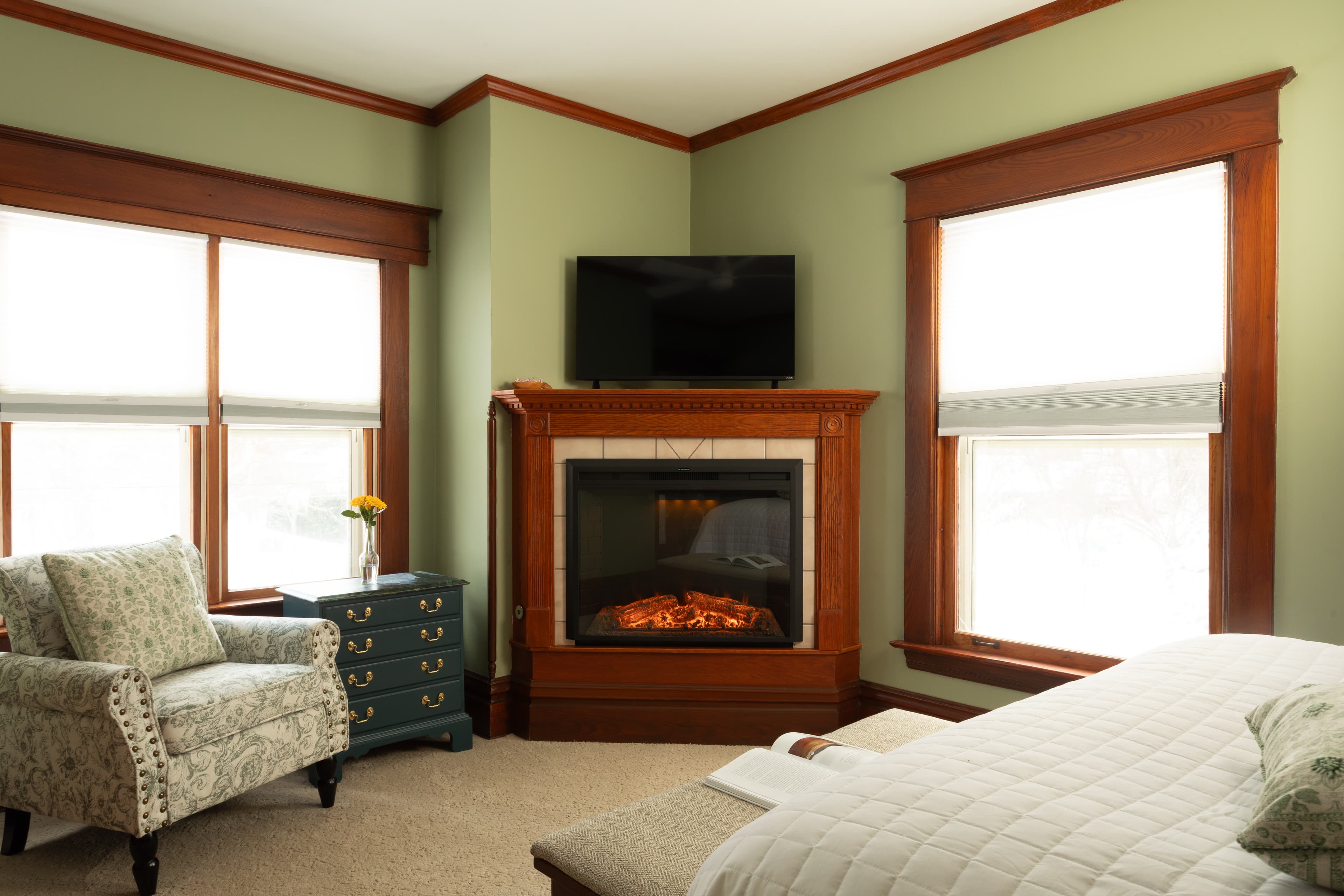Bedroom with Clary Sage walls, a fireplace, and a sink vanity facing Butler Street.