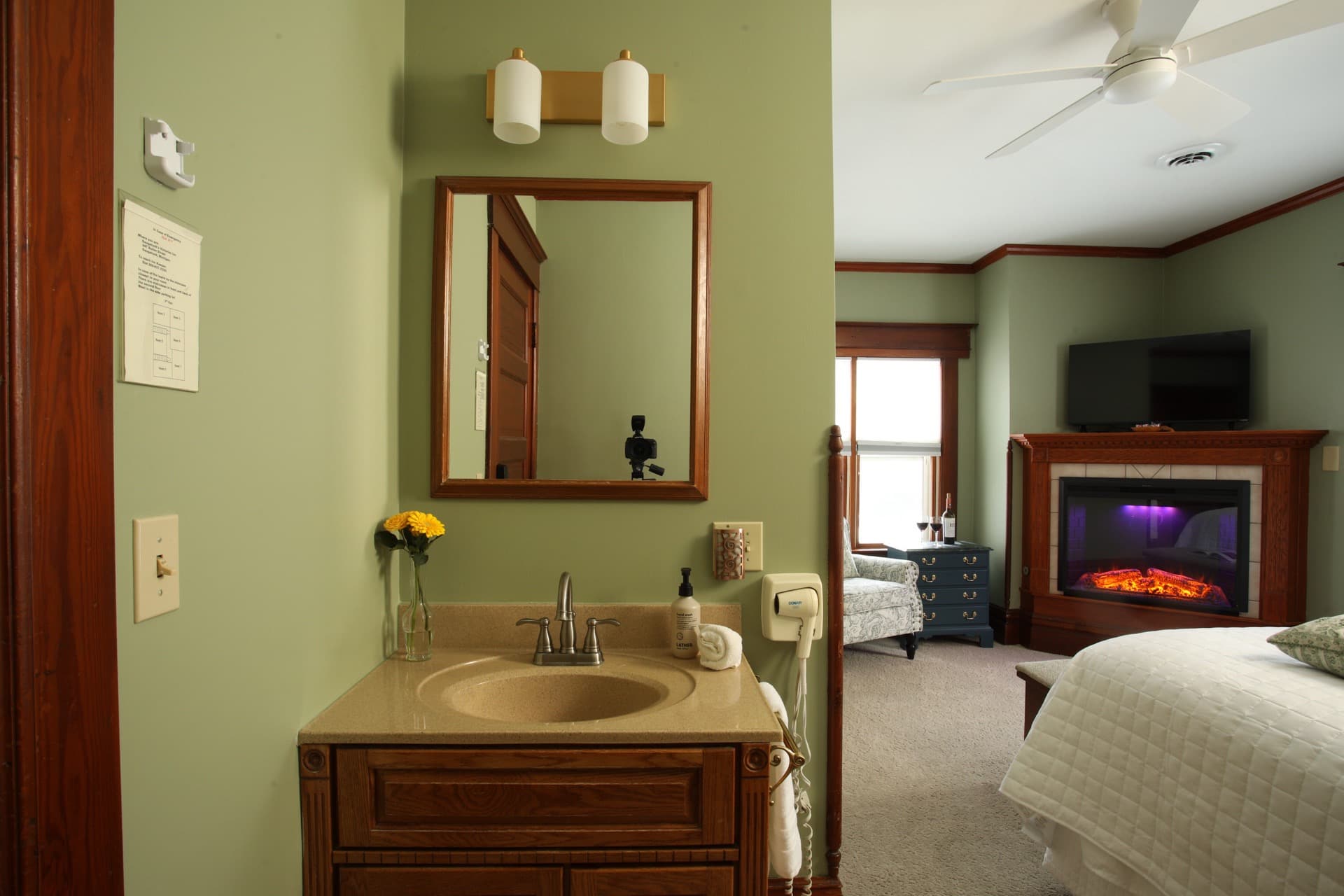 Bedroom with Clary Sage walls, a fireplace, and a sink vanity facing Butler Street.
