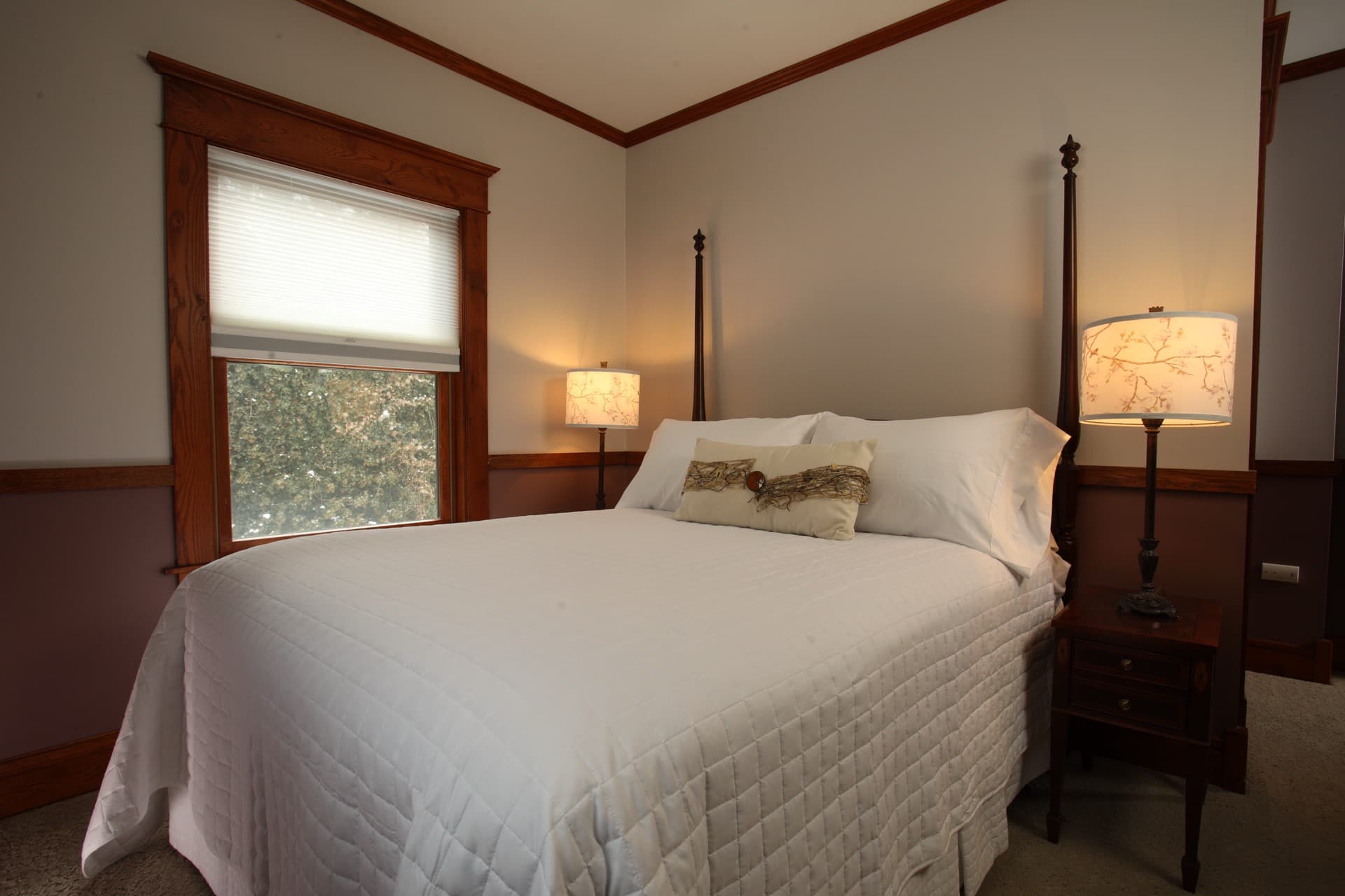 Two tone bedroom with a 2 post Heckman bed,  a fireplace, and a flat-screen TV.