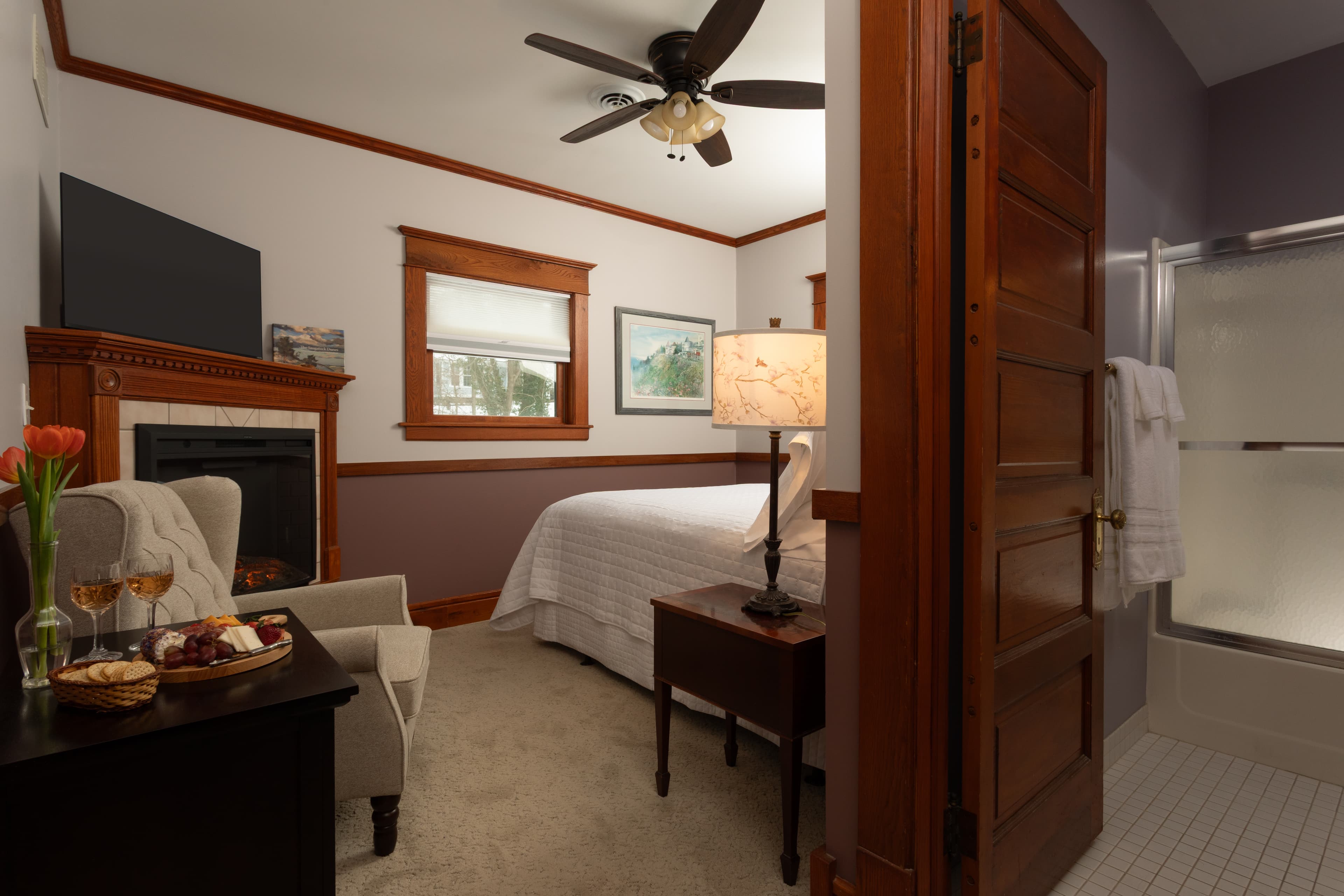 Two tone bedroom with a 2 post Heckman bed,  a fireplace, and a flat-screen TV.