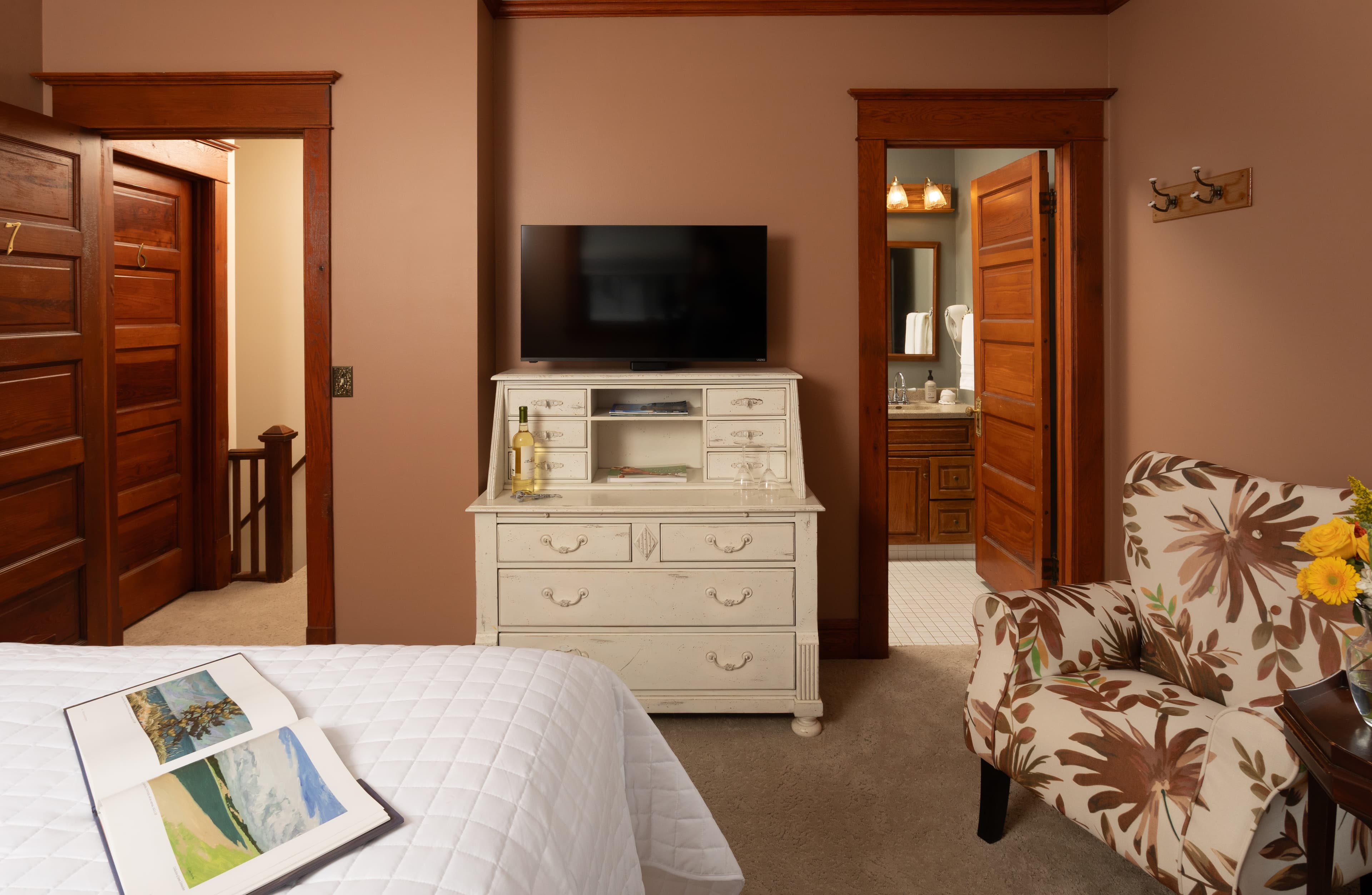 Bedroom with Queen bed, a fireplace, and Rose Renwick painted walls.