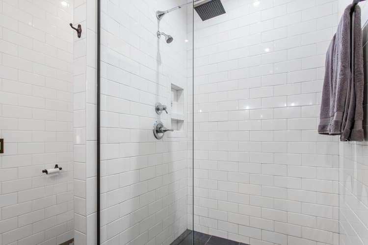 White subway tile shower with glass door.
